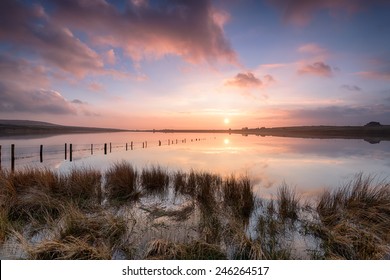 Dramatic sunset over Dozmary Pool a small mysterious lake on Bodmin Moor in Cornwall where legend has it that King Arthur threw his famous sword Excalibur back to the Lady of the Lake