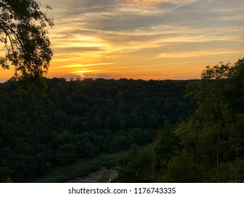Dramatic sunset over a forest with a river in the distance