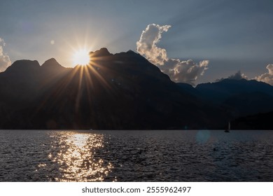 Dramatic sunset over Garda lake seen from lakeside town Nago-Torbole, Trentino, Italy. Sun setting behind silhouette of majestic mountain Garda Prealps. Golden glow creating mesmerizing reflection - Powered by Shutterstock