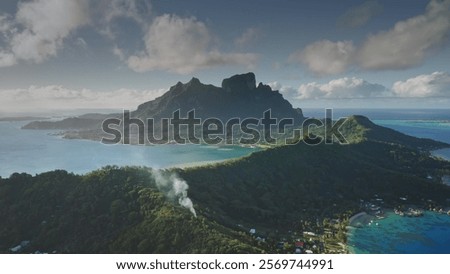Dramatic sunset over green mountains cascade and crystal clear turquoise water lagoon under dark blue sky. Idyllic tropical paradise Bora Bora island. Popular tourist destination. Aerial drone view