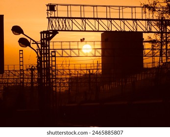 Dramatic sunset over an industrial railway yard with silhouetted tracks and wires, creating a striking urban landscape. - Powered by Shutterstock