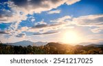 Dramatic sunset over mountain landscape. Beautiful landscape foggy hills twilight time. Blue golden sky sunrise dramatic beautiful landscape mountain. Dawn sky gold dusk time cloudscape with sunlight