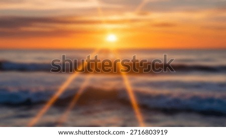 Dramatic sunset over ocean with sunbeams Orange sky and waves at the beach.