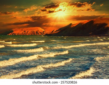 Dramatic sunset over a rocky coast - Powered by Shutterstock