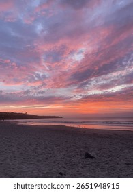 Dramatic sunset over sandy beach.
vibrant pink and purple clouds fill the sky above a peaceful beach at sunset. The colorful seascape creates a serene and inspiring atmosphere.