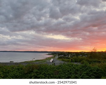 Dramatic sunset over the sea with a cloud-covered sky in Ebeltoft, Denmark. With yellow, red, purple, blue and gray clouds