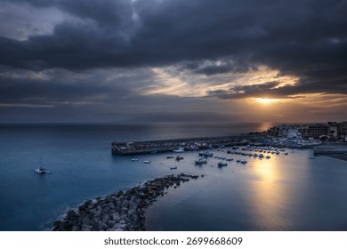 Dramatic Sunset Over Small Coastal Harbor with Storm Clouds, Tenerife, Canary Islands