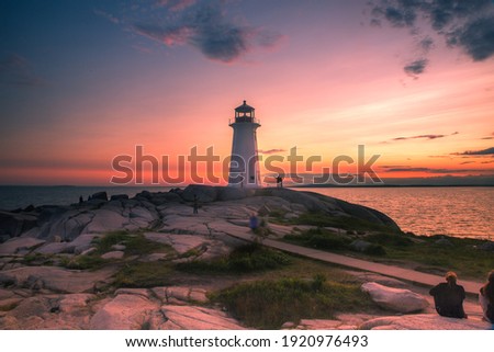 A dramatic sunset at Peggy's Cove Lighthouse, Atlantic Coast, Nova Scotia, Canada. The most visited tourist location in the Atlantic Canada and famous Lighthouse captured with vibrant colors