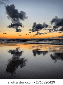 Dramatic sunset reflection on wet beach sand in Bulduri, Jūrmala, Latvia, July 2020