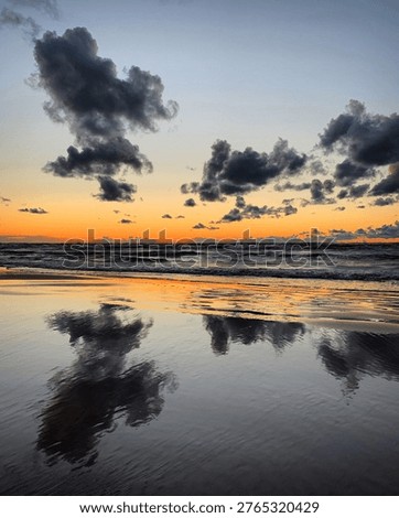 Dramatic sunset reflection on wet beach sand in Bulduri, Jūrmala, Latvia, July 2020