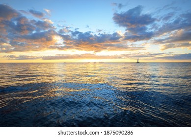 Dramatic Sunset Sky Above The Sea. Colorful Glowing Golden Clouds, Still Water Surface Texture Close-up. Sailing After The Storm, View From The Yacht. Epic Seascape. Nature, Fickle Weather