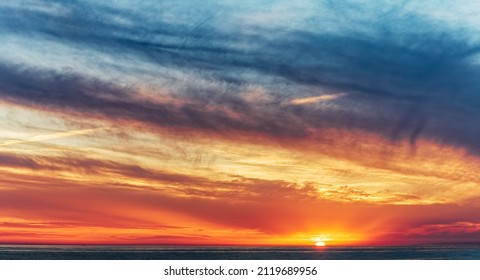 Dramatic sunset sky background. Clouds and sun by the horizon.  Soft focus.