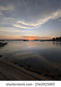 Dramatic sunset sky with clouds. Dramatic sunset over the sea with some small boat at the beatiful island