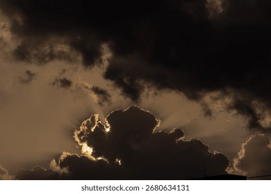  Dramatic sunset sky with dark clouds and sunbeams.