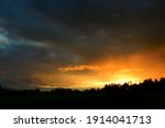 Dramatic sunset in sky over landscape. Stock Photo