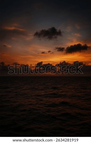 Dramatic sunset sky over the ocean with vivid orange and purple tones, capturing a peaceful and contemplative moment in nature.