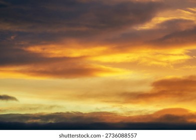 Dramatic sunset sky with vibrant orange and yellow clouds creating a fiery spectacle