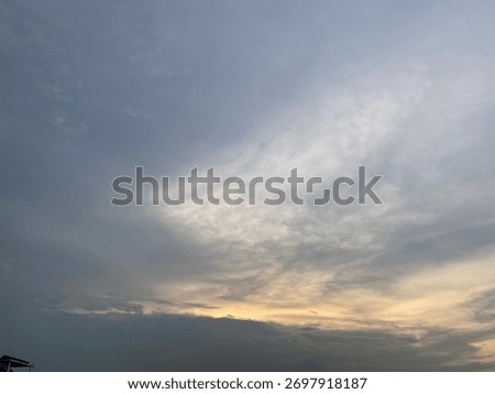 Dramatic sunset sky with wispy cirrus clouds and dark stratocumulus. Weather background, abstract nature, and atmospheric texture backdrop.