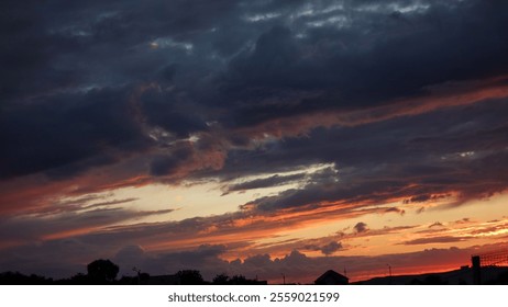 Dramatic sunset with vibrant orange and deep blue clouds creating a stunning evening sky.