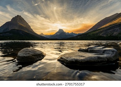 A dramatic sunset view behind the mountains over the lake