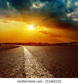 Dramatic Sunset And White Line On Asphalt Road To Horizon