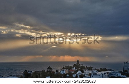 Dramatic thunderclouds over mediterranean sea with sun rays breaking through