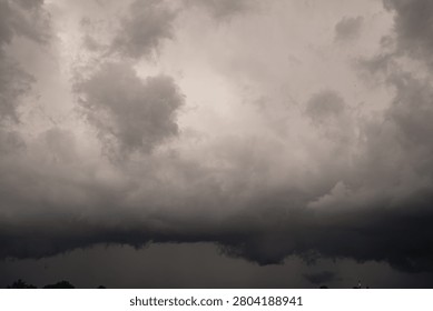 Dramatic Thunderstorm Clouds Filling the Sky Before Rain. Rain Filled Thunderclouds Covering the Sky Before the Storm. Dark dramatic storm clouds gathering in the sky before heavy rainfall. Atmospheric cloudscape featuring dense cumulonimbus formations, overcast weather, and approaching thunderstorm. Perfect background for weather, climate, meteorology, nature, environmental concepts, forecasts, dramatic skies, and seasonal weather themes.
