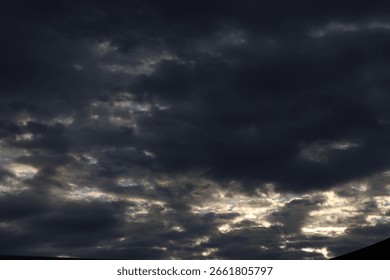 Dramatic timelapse of dark storm clouds rolling across a turbulent blue sky at sunset