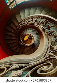 A dramatic top-down view of a classic spiral staircase.