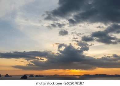 Dramatic tropical sunset sky over the ocean with dark clouds, perfect for travel, vacation and nature tourism background concepts
