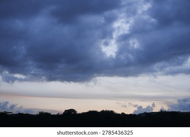 Dramatic Twilight Sky Heavy Clouds Loom Over Silhouetted Horizon at Dusk.