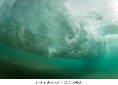 dramatic under water scene of a wave crashing in the ocean on a tropical island beach, design and copy space