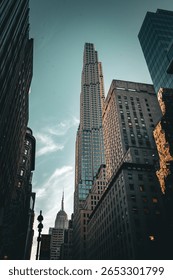 Dramatic upward view of a modern skyscraper surrounded by historic buildings under a twilight sky.
