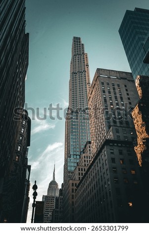 Dramatic upward view of a modern skyscraper surrounded by historic buildings under a twilight sky.