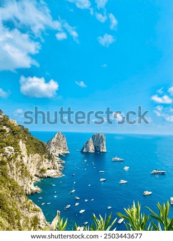 Dramatic view of Capri's Faraglioni, with towering sea stacks rising majestically from crystal-clear waters, epitomizing natural splendor and coastal grandeur.