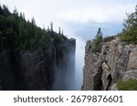 A dramatic view from the cliffs of Sleeping Giant Provincial Park in Ontario, Canada, with Lake Superior and clouds in the distance.