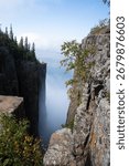 A dramatic view from the cliffs of Sleeping Giant Provincial Park in Ontario, Canada, with Lake Superior and clouds in the distance.
