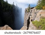 A dramatic view from the cliffs of Sleeping Giant Provincial Park in Ontario, Canada, with Lake Superior and clouds in the distance.
