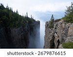 A dramatic view from the cliffs of Sleeping Giant Provincial Park in Ontario, Canada, with Lake Superior and clouds in the distance.