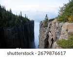 A dramatic view from the cliffs of Sleeping Giant Provincial Park in Ontario, Canada, with Lake Superior and clouds in the distance.