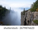 A dramatic view from the cliffs of Sleeping Giant Provincial Park in Ontario, Canada, with Lake Superior and clouds in the distance.
