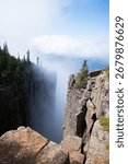 A dramatic view from the cliffs of Sleeping Giant Provincial Park in Ontario, Canada, with Lake Superior and clouds in the distance.