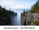 A dramatic view from the cliffs of Sleeping Giant Provincial Park in Ontario, Canada, with Lake Superior and clouds in the distance.