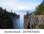 A dramatic view from the cliffs of Sleeping Giant Provincial Park in Ontario, Canada, with Lake Superior and clouds in the distance.
