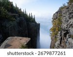 A dramatic view from the cliffs of Sleeping Giant Provincial Park in Ontario, Canada, with Lake Superior and clouds in the distance.