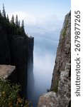 A dramatic view from the cliffs of Sleeping Giant Provincial Park in Ontario, Canada, with Lake Superior and clouds in the distance.