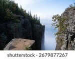 A dramatic view from the cliffs of Sleeping Giant Provincial Park in Ontario, Canada, with Lake Superior and clouds in the distance.