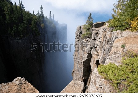 A dramatic view from the cliffs of Sleeping Giant Provincial Park in Ontario, Canada, with Lake Superior and clouds in the distance.