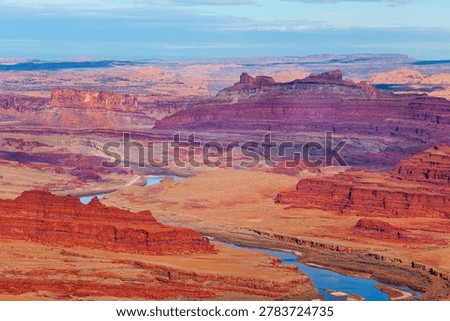 Dramatic view of Colorado river flowing through red rock prehistoric landscape from Anticline overlook of Canyonlands National park, Utah, USA