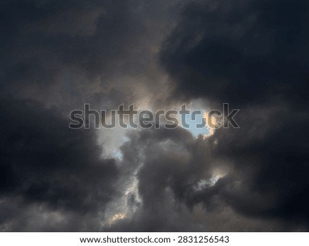 Dramatic view of dark storm clouds overcasting bright blue sky background before heavy rain, beautiful natural pattern of heavy grey cumulus thunderclouds and stormclouds before intense thunderstorm at summer day, climate and meteorology concept.
